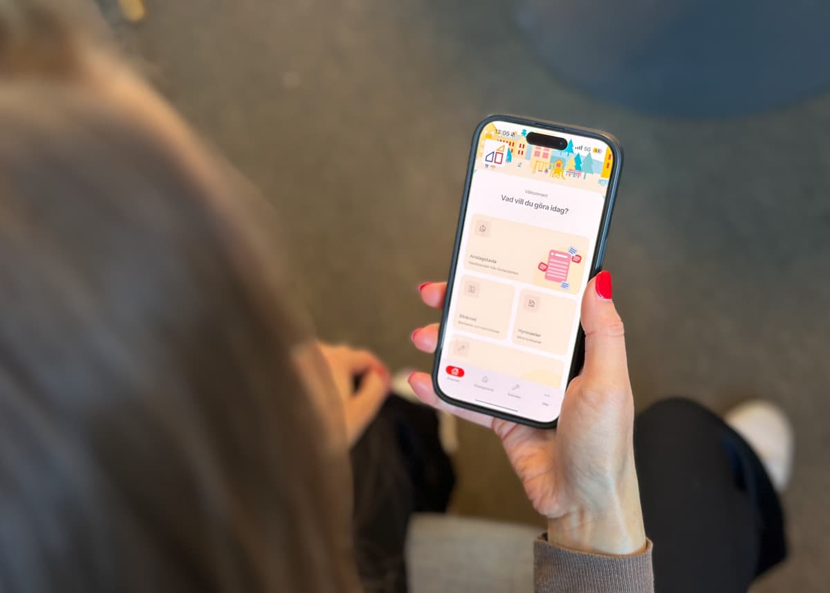 Person som håller i en mobiltelefon och scrollar i en app