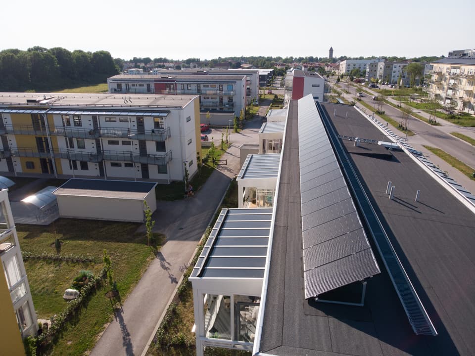 Fågelperspektivet med närbild över solceller på ett av bostadshusens tak.