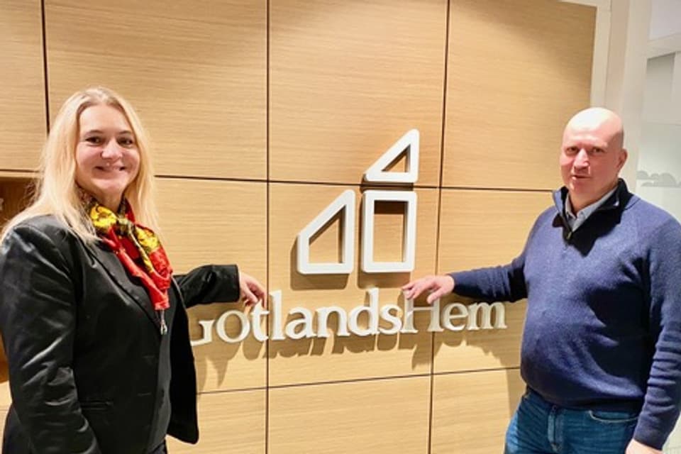 Therése Lindström från Stadsmissionen Gotland och Joakim Martell sstår vid GotlandsHems skylt. Anledningen är att visa ett nytt samarbete mellan organisationerna.