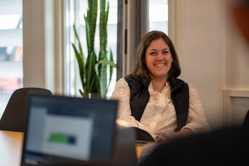 En kvinna sitter framför en bärbar dator.